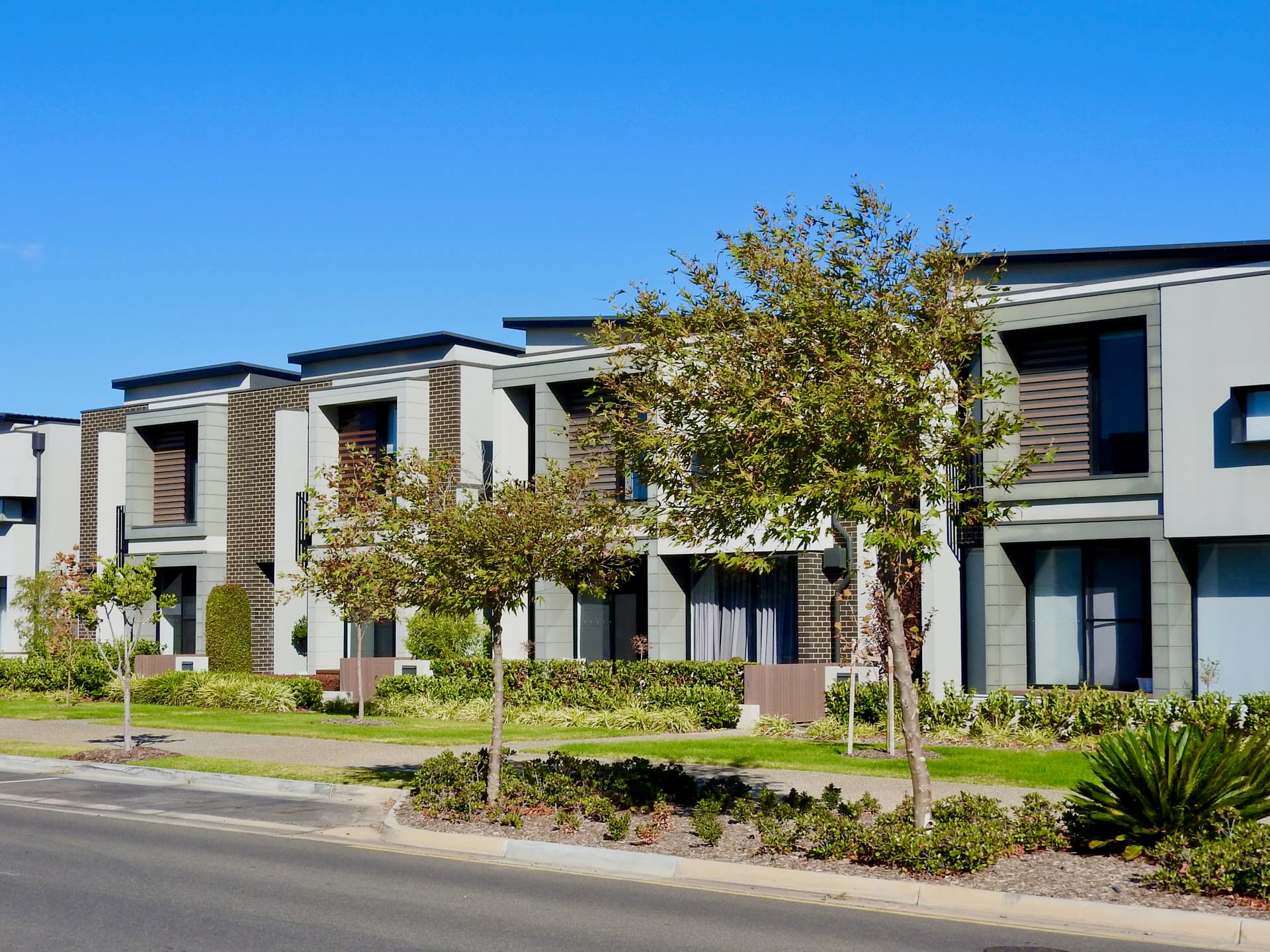 Two-storey townhouses along a landscaped street in West Lakes, South Australia